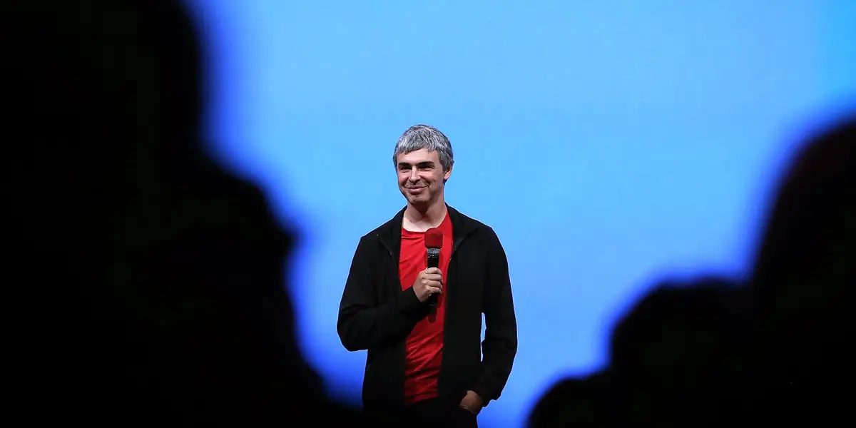 Larry Page speaking at an event with Google logo backdrop